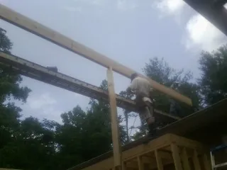 Carpenter setting a ridge beam over a new addition frame — Ice Dam Removal by Roofing Brothers in Nowata