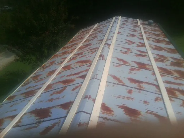 Rusted metal roof panels with new wood purlins before replacement — Storm Damage Roof Repair in Nowata by Roofing Brothers