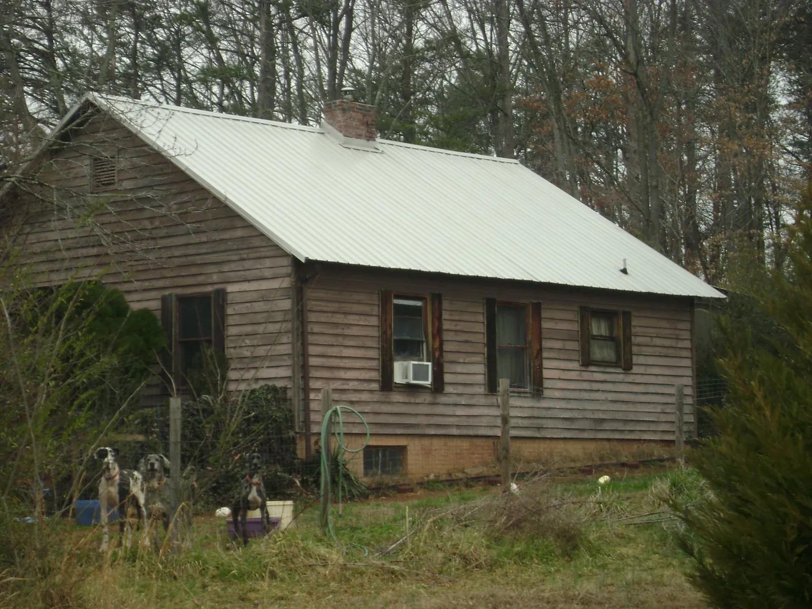 White metal roof on an old wood sided farmhouse, from a Metal Roof Installation job in Nowata